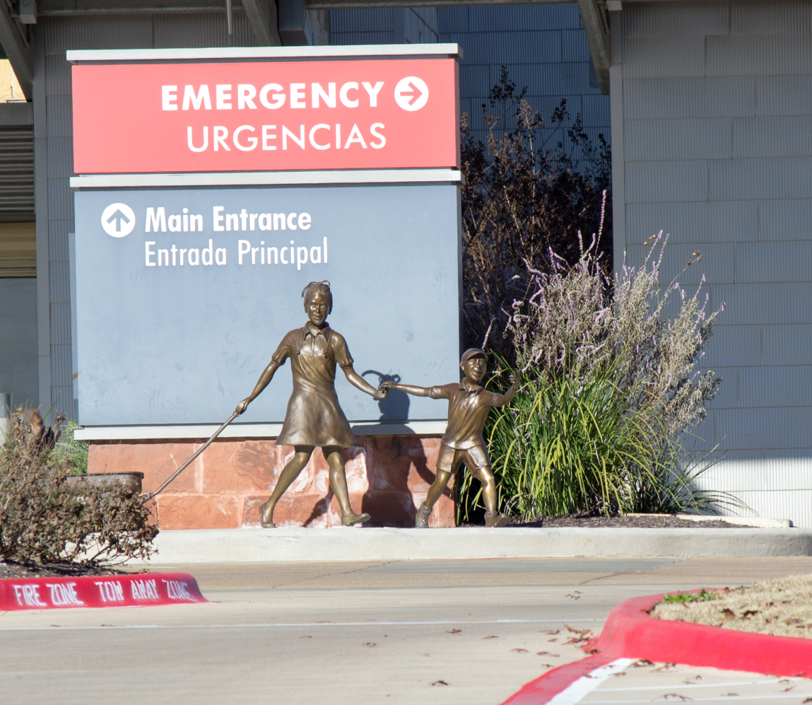 Emergency entrance sign with small statue of woman and child. Dell Childrens Medical Center.