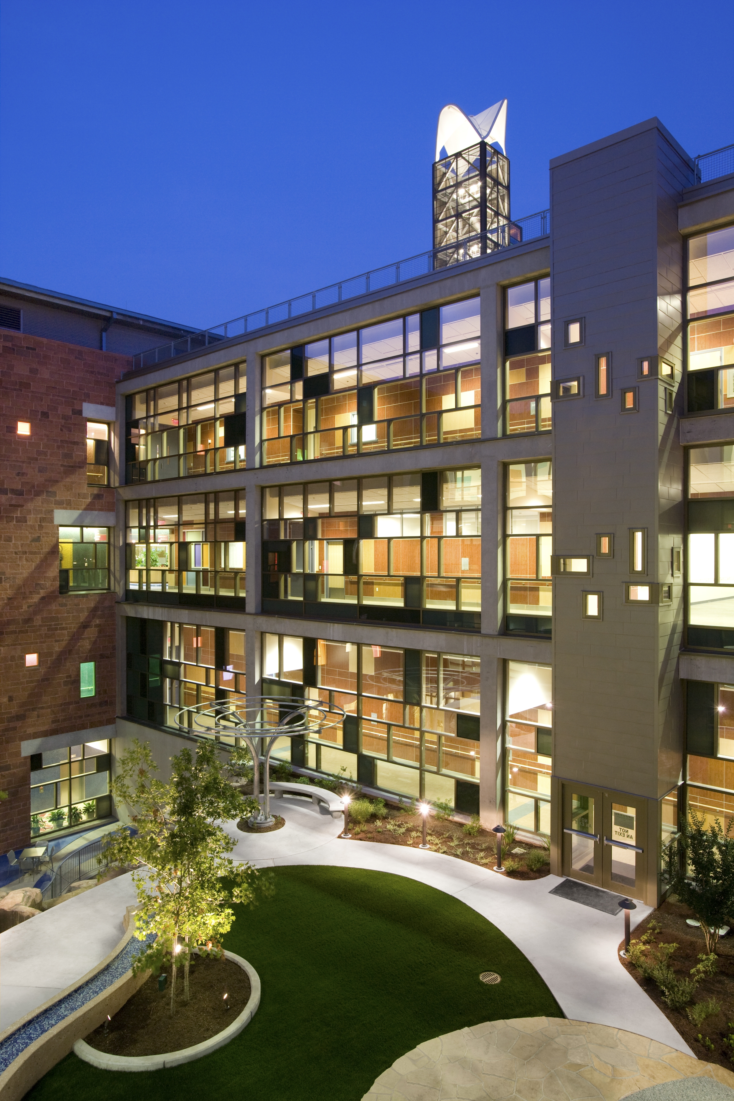Photo at dusk with lights inside of the outside of Dell Childrens Medical Center in Austin, TX.